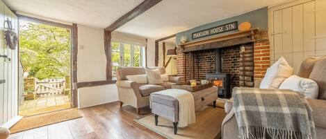 A cozy living room with a fireplace, a sofa, and a chair.