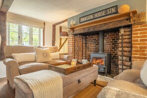 Un salon confortable avec une cheminée, une enseigne indiquant « Mansion House STN » et un ensemble de canapés.