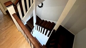 Eine Holztreppe mit weißen Geländern und einer dunklen Holzhandläufe.