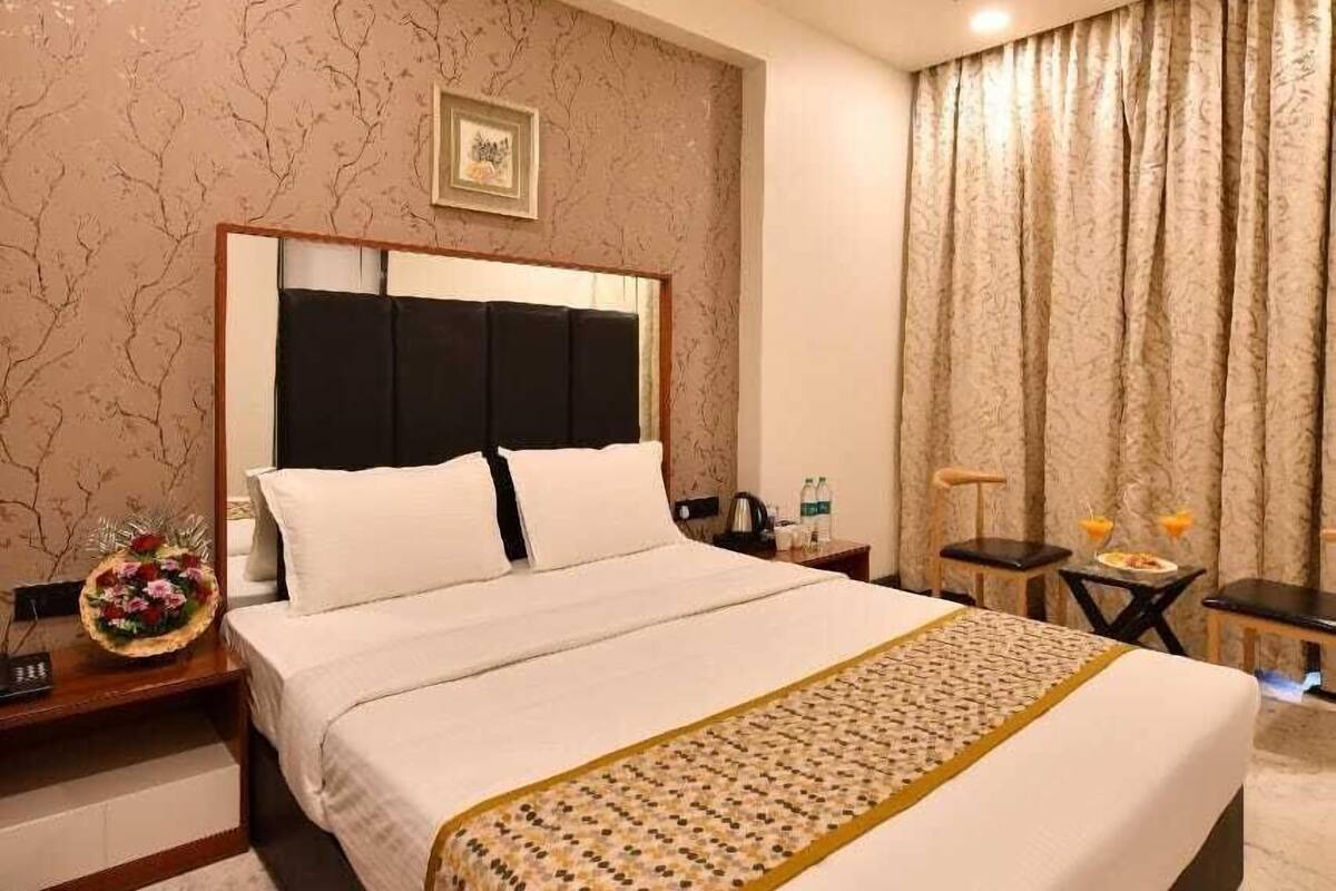Habitación de hotel con una cama grande, una mesita de noche, una pequeña mesa y un ventilador de techo.