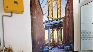 A mural of a bridge with a yellow structure and a cityscape in the background.