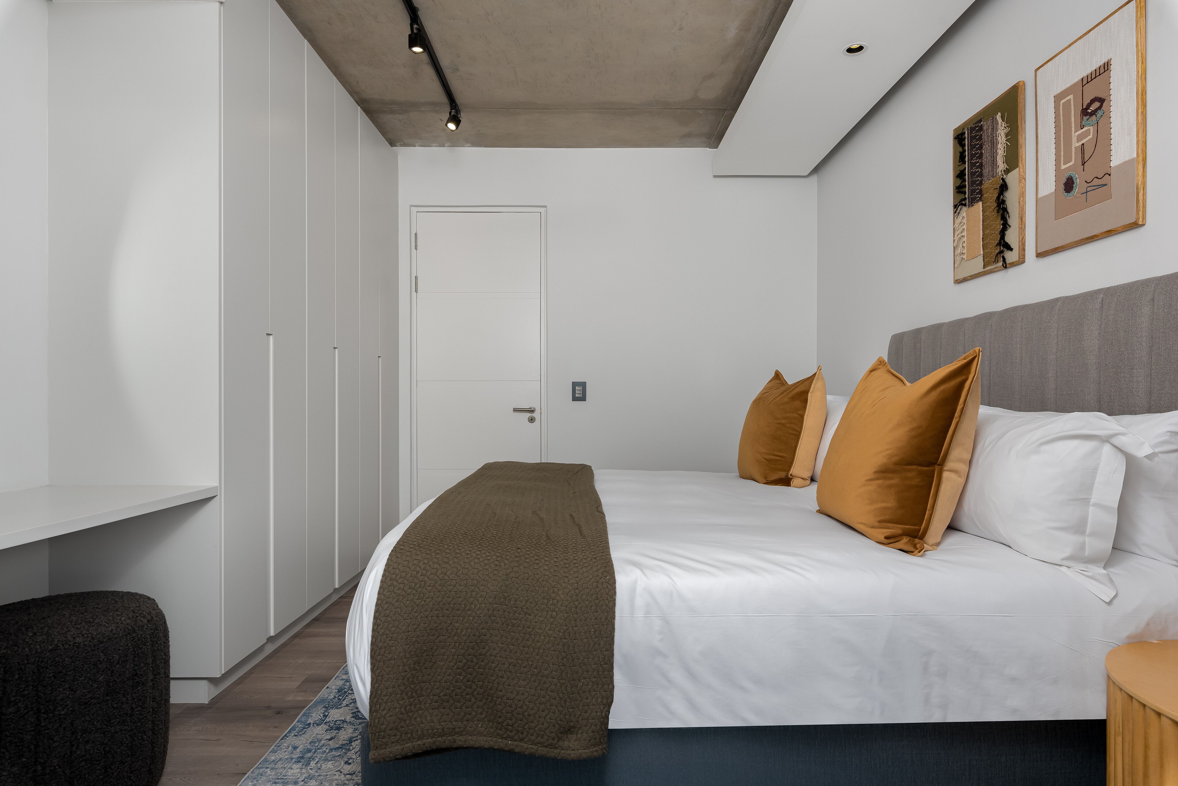 Ein modernes Schlafzimmer mit einem großen Bett, einem Kleiderschrank und einem Schreibtisch.