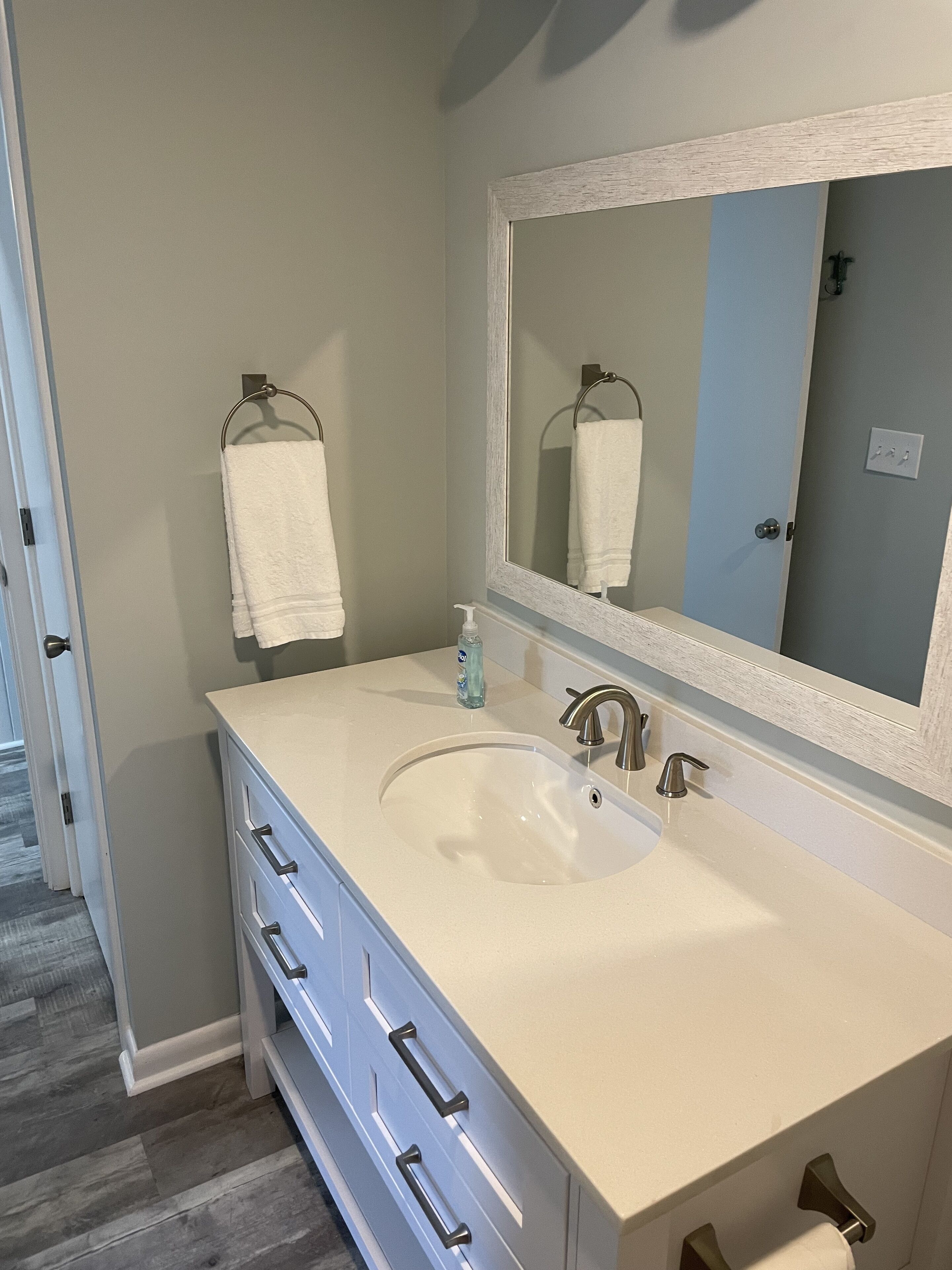 Une salle de bain avec un double lavabo, un grand miroir et un porte-serviettes.