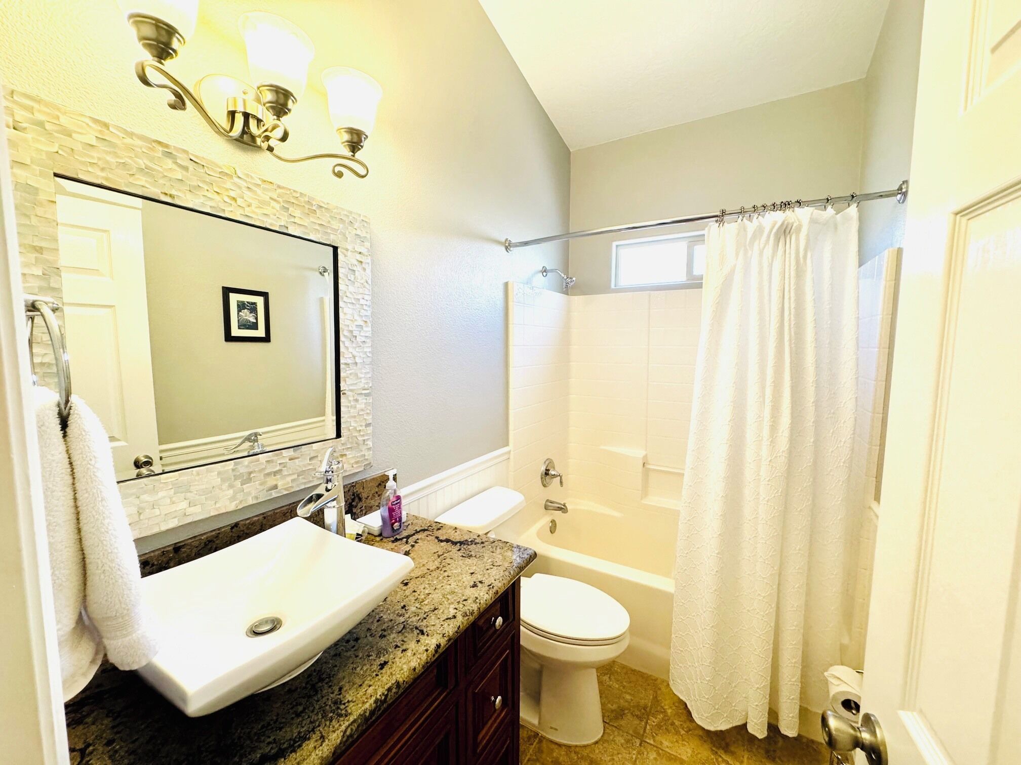 A bathroom with a sink, toilet, bathtub, and shower curtain.