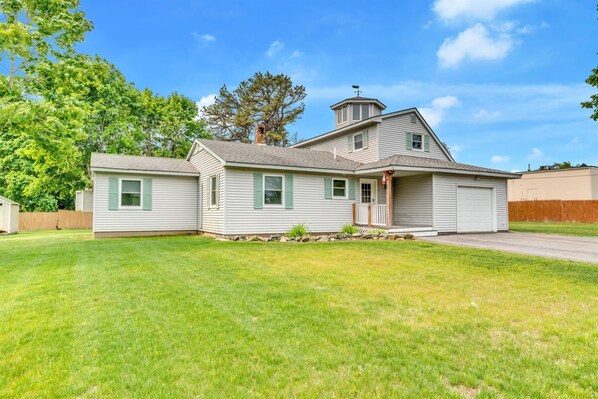 A two-story house with a garage, a covered porch, and a well-maintained lawn. - Walk To Wells Harbor! Ping Pong Table & Large Yard (Wells)