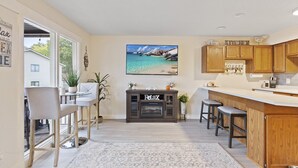A modern kitchen with wooden cabinets, a bar area, and a fireplace. - Lakefront Couple Retreat near Hot Spots and Dining (Lake Ozark)