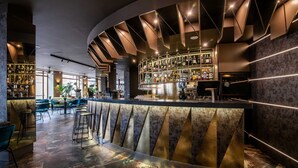 Eine moderne Bar mit einer gebogenen Theke, Barhocker und einer gut sortierten Flaschenauswahl.
