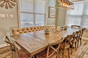 A dining area with a wooden table, cushioned bench, and chairs. - Ocean View * 5BR Luxury Beach Resort Home (Ocean View)