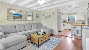 A living room with a grey sofa, a wooden coffee table, and a ceiling fan. - A Private Oasis Complex in Naples (Naples)