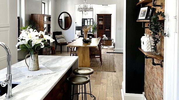 A spacious kitchen with a marble countertop, wooden bar stools, and a central island. - Brewery District Homestead  (Columbus)