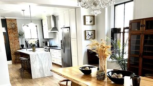 A modern kitchen with a marble island, stainless steel appliances, and a chandelier. - Brewery District Homestead  (Columbus)