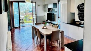 A spacious kitchen with a dining area, large windows, and a view of the outdoors. - Sonhozinho House Colico, Beautiful Villa with Lake and Mountain View (Lombardia)