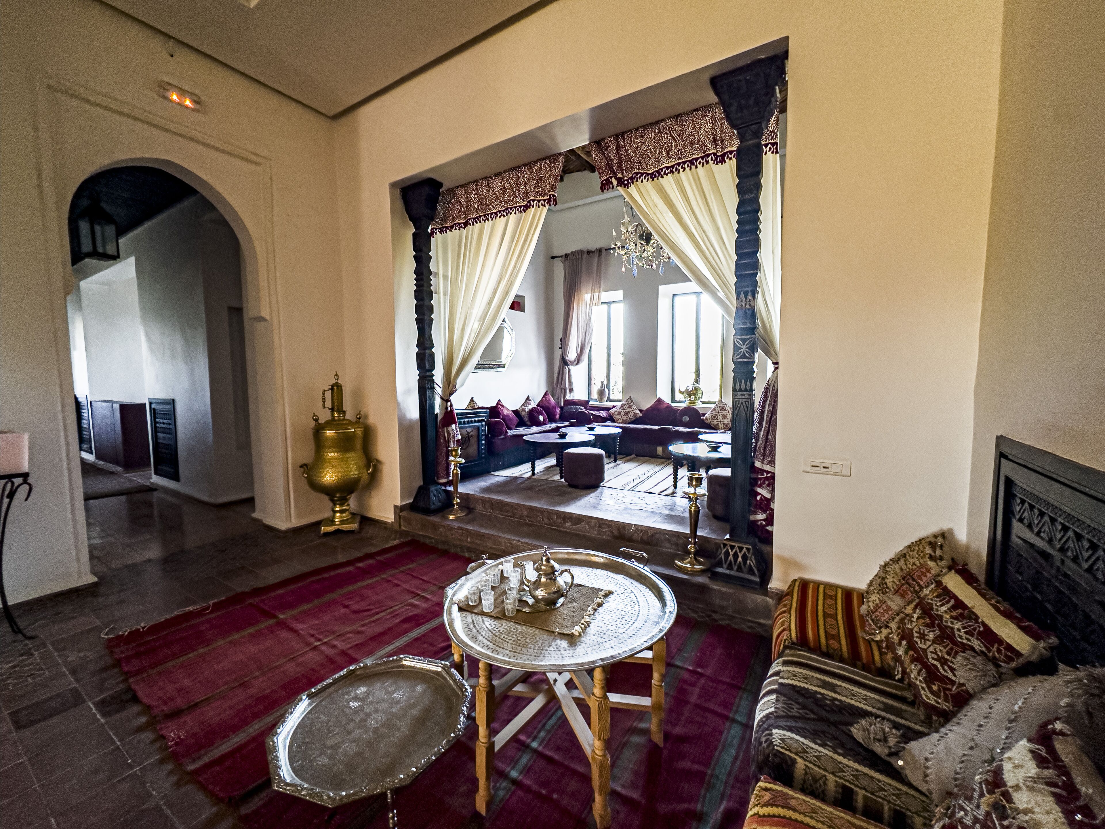 A traditional interior with a large mirror, a sofa, a coffee table, and a patterned rug.