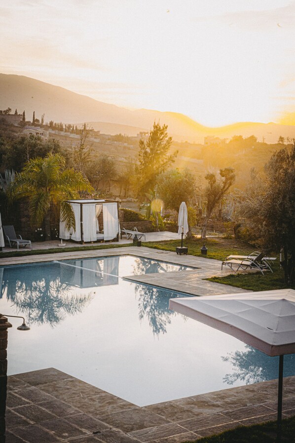 Een buitenzwembad en ligstoelen