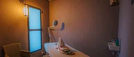 Una habitación con una cama, una silla, un ventanal, un lavamanos y una lámpara.