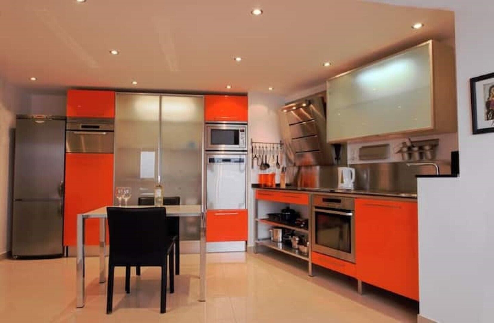 A compact kitchen with modern appliances, a dining table, and chairs.