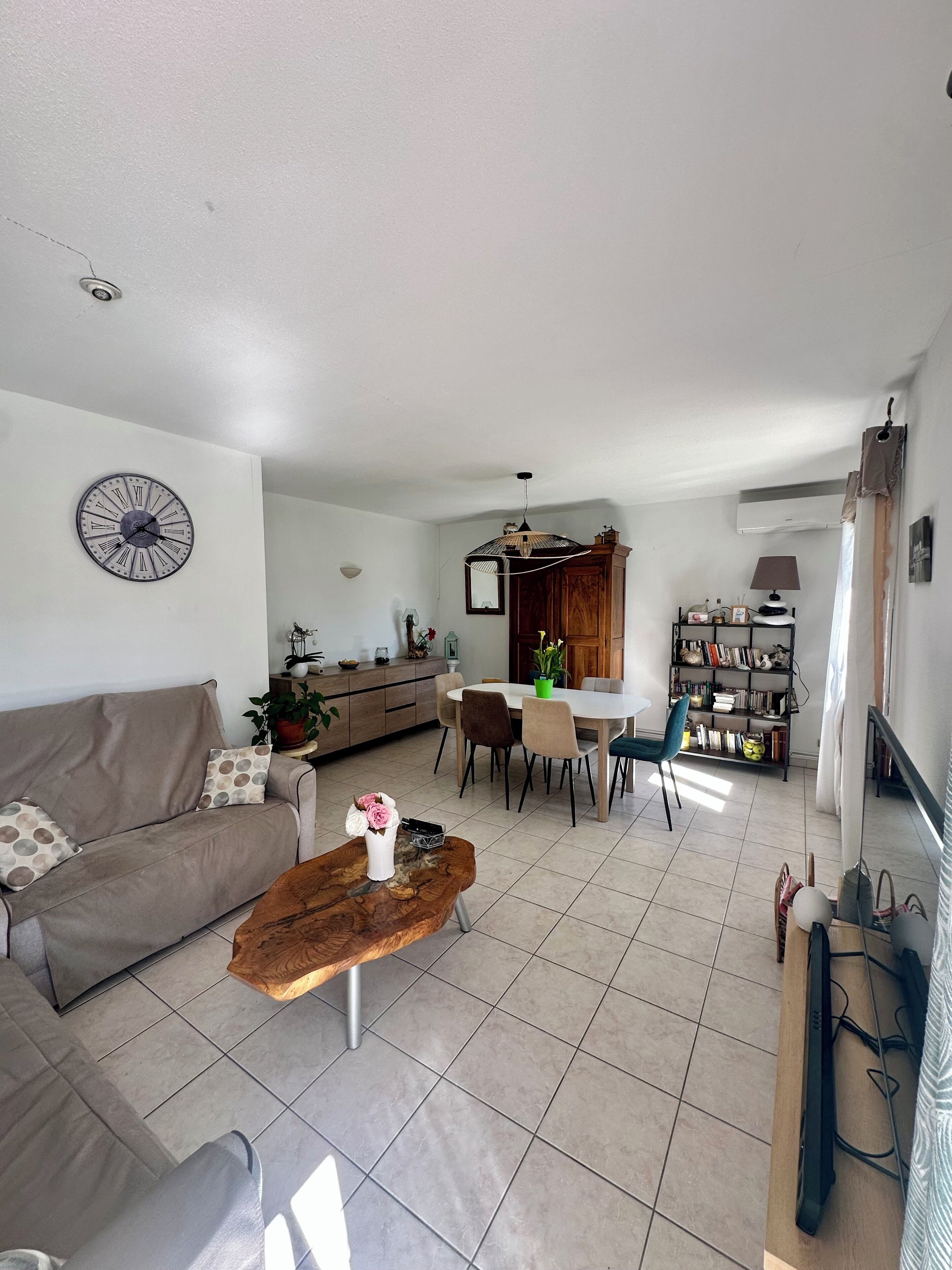 Un salon moderne comprenant un canapé, une table basse, un coin repas et une cuisine.