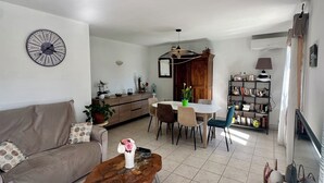 A modern living room with a sofa, coffee table, dining area, and kitchen. - Pretty villa with private pool (Valréas)