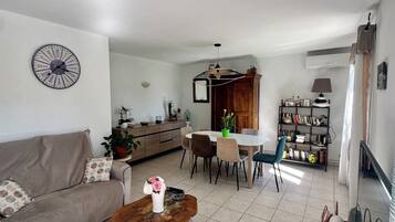 Un salon moderne comprenant un canapé, une table basse, un coin repas et une cuisine.