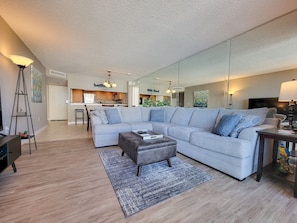Relax in this spacious living area with a large L-shaped sofa and matching ottoman, complemented by a dining table and chairs.