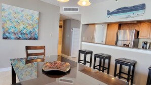 A modern kitchen with a stainless steel refrigerator, wooden cabinets, and a countertop with a coffee machine. - 1201 South Hampton 2 Bedroom Condo (Myrtle Beach)