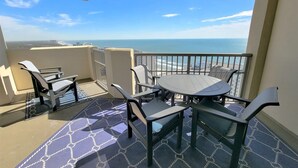 A balcony with a view of the ocean, furnished with chairs and a table. - 2307 Royale Palms 3 Bedroom Condo (Myrtle Beach)