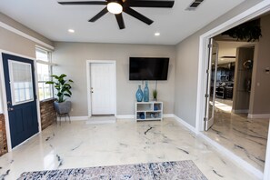 Relax in this inviting space with a flat-screen TV, potted plant, and comfortable seating area.