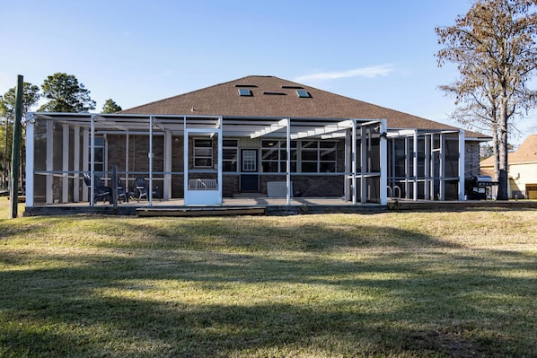 A modern building with a glass facade, a covered entrance, and a sloped roof. - Bayou, Blues & Views (Pensacola)