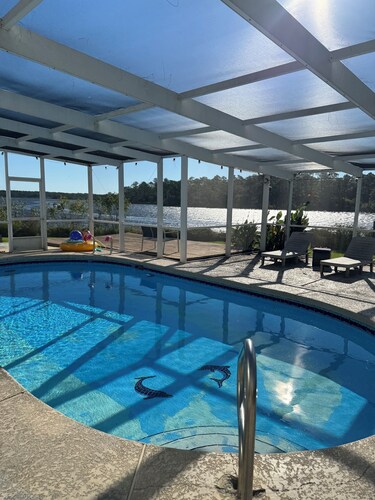 Enjoy this waterfront home with a pool, dock, and Blue Angels! Bring your boat!