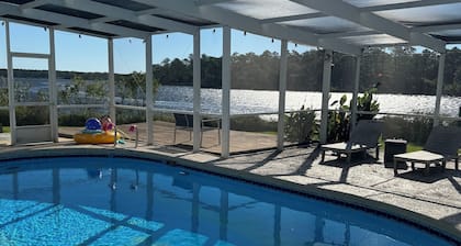 Enjoy this waterfront home with a pool, dock, and Blue Angels! Bring your boat!