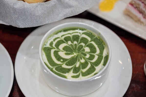A bowl of green and white patterned soup on a white plate. - Trulyy The Shakti Vilas (Udaipur)