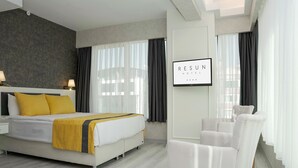Una habitación de hotel moderna con cama, lámparas de noche, escritorio y una silla.