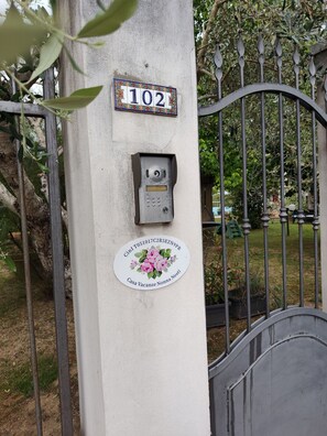 Número de casa 102, un teclado de seguridad y una placa con diseño floral.