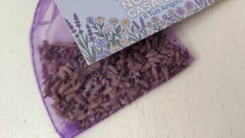 A purple drawstring bag with a tag, containing what appears to be dried herbs or spices.
