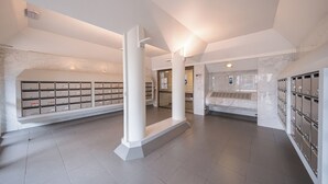 A modern interior with marble walls, a central column, and metal lockers. - Westhinder 200m From Sea (De Panne)