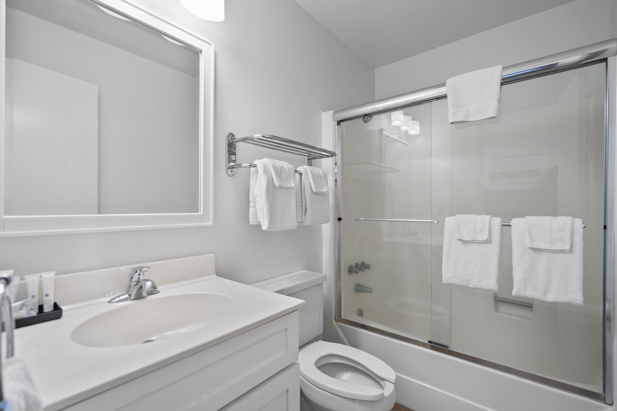 A modern bathroom with a sink, toilet, and glass-enclosed shower.