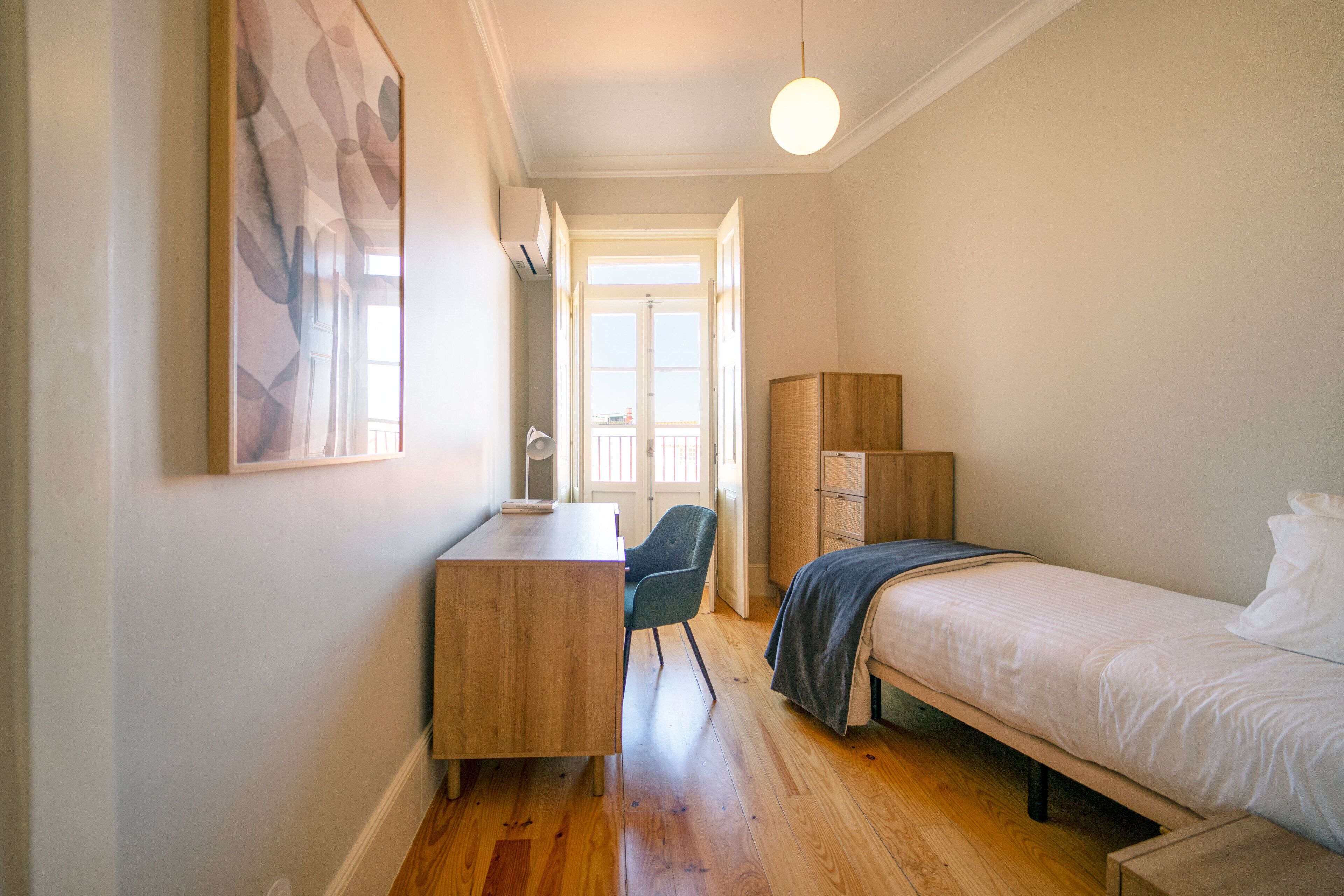 Une chambre à coucher avec un lit, un bureau, une chaise et une armoire.