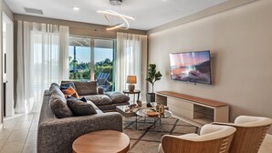 Ein modernes Wohnzimmer mit einer Couch, einem Couchtisch und einem Fernseher.