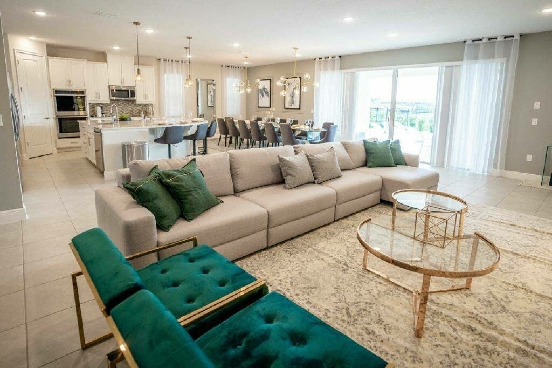Un salon moderne avec un canapé beige, des poufs verts et une table basse en verre.
