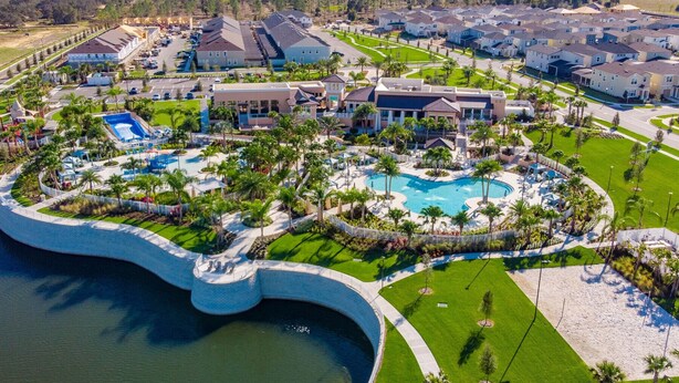 Vogelperspektive eines Resorts mit zentralem Pool, umliegenden Villen und direktem Strandzugang.