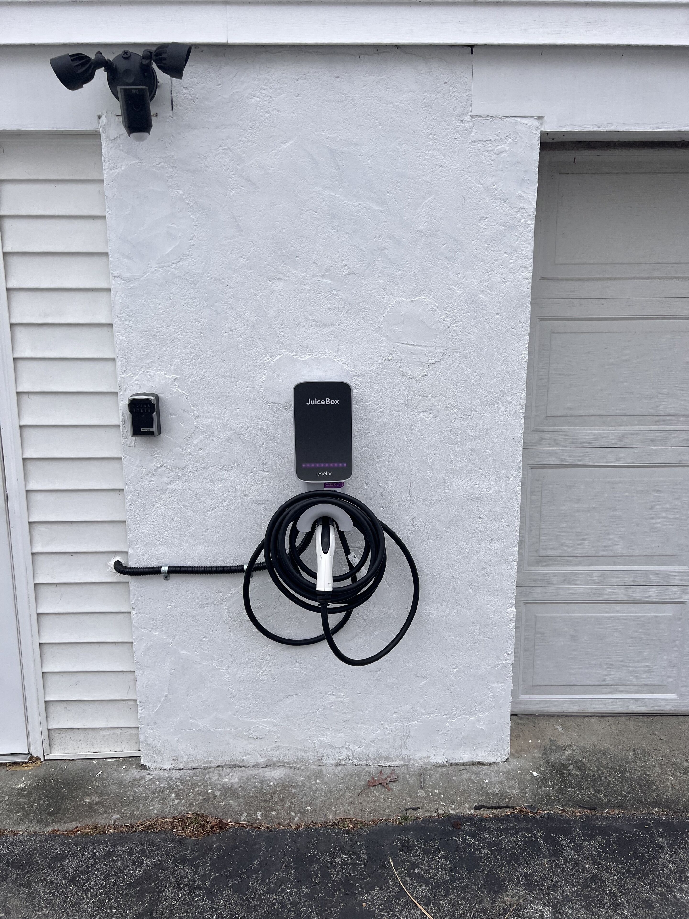 En garageport med en säkerhetskamera och en laddstation av typen JuiceBox.
