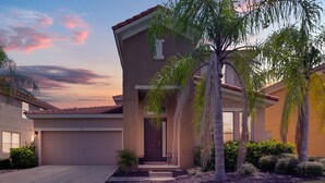 A two-story house with a garage, a front porch, and a well-maintained lawn. - Last Minute Disney Getaway! Luxury Villa with Private Pool. Book Now! #65721 (Orlando)