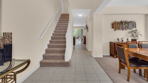 A spacious hallway with a carpeted staircase leading to another room. - Last Minute Disney Getaway! Luxury Villa with Private Pool. Book Now! #65721 (Orlando)