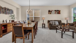 A spacious living room with a dining area, a sofa set, and a chandelier. - Last Minute Disney Getaway! Luxury Villa with Private Pool. Book Now! #65721 (Orlando)