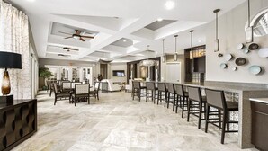 A spacious kitchen with a central island, modern bar area, and a dining space with multiple chairs.