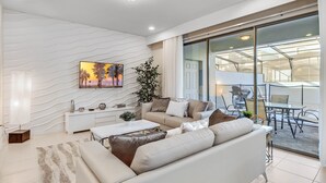 Un salon moderne avec un canapé, une table basse et un tableau accroché au mur.