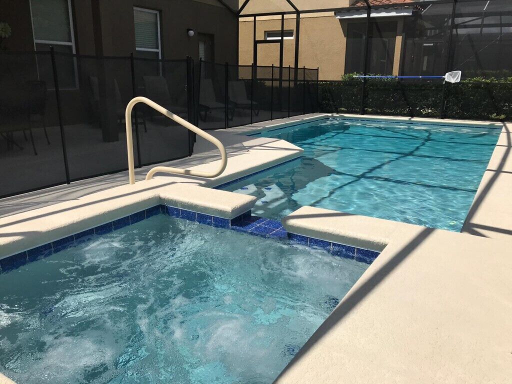 A swimming pool with a diving board and a safety fence.