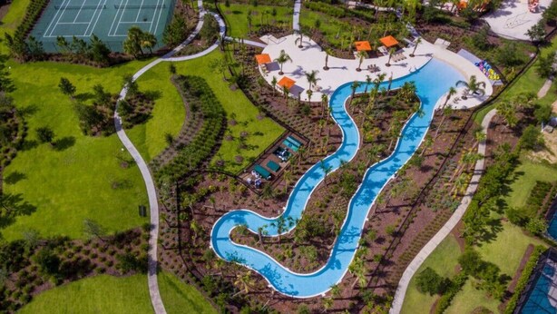 An aerial view of a resort with a winding pool, green lawns, and a tennis court. - Last Minute Disney Getaway! Private Pool, Hot Tub & Game Room. Book Now! #65771 (Orlando)