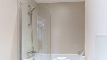 Bathtub, hair dryer, towels, shampoo