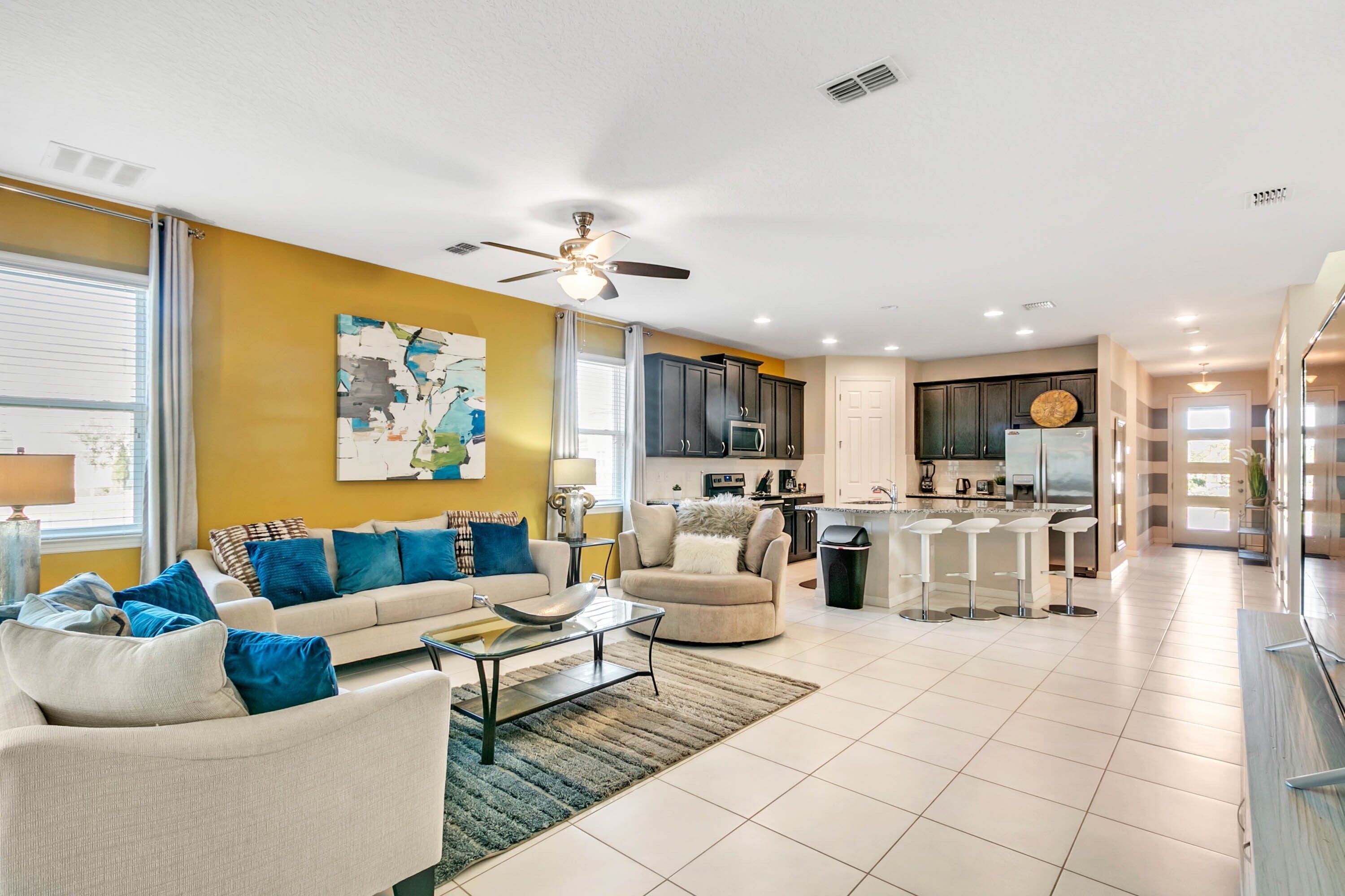 A modern living room with a sofa, coffee table, and a ceiling fan.